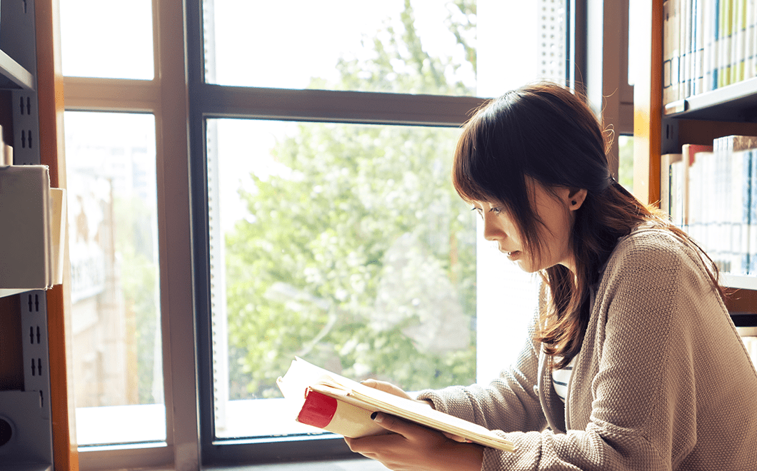 窓辺で本を読む女性